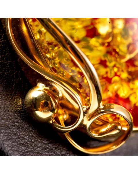 Ciondolo in ambra rosso cognac: gemma con inclusioni dorate, eleganza senza tempo.