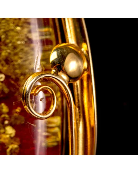 Ciondolo in ambra rossa: inclusioni dorate e raffinata eleganza.