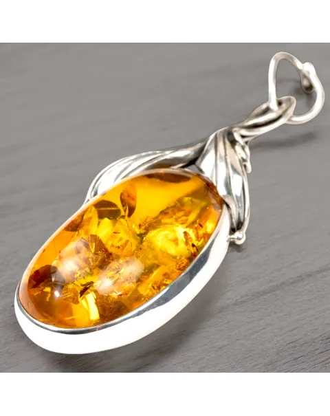 Ciondolo in argento con ambra color miele e inclusioni a forma di petali: eleganza naturale e armonia.