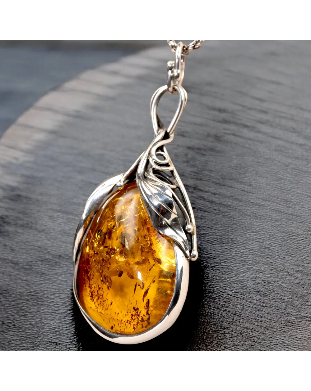 Ciondolo in argento con ambra color miele: fascino e protezione.