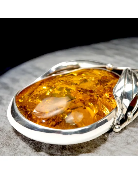 Ciondolo in argento con ambra color miele: fascino e protezione.