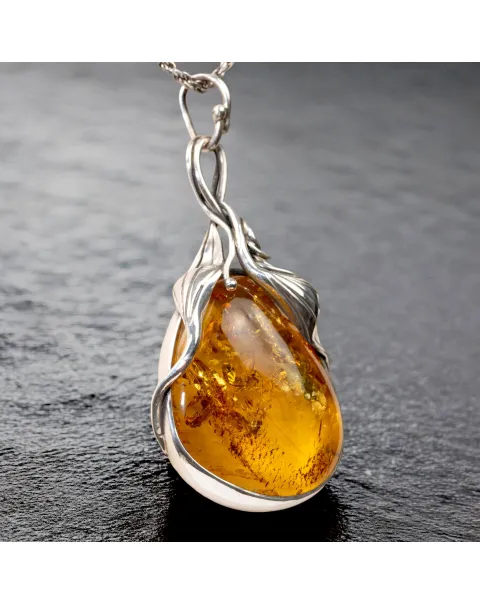 Ciondolo in argento con ambra color miele: fascino e protezione.