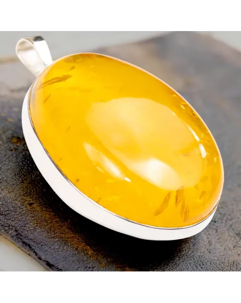 Ciondolo in argento con ambra color miele: eleganza e protezione energetica.