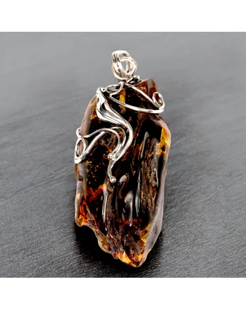 Ciondolo in argento con ambra grezza color cognac: connessione con la natura e protezione spirituale.