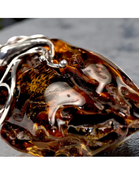 Ciondolo in argento con ambra grezza color cognac: connessione con la natura e protezione spirituale.