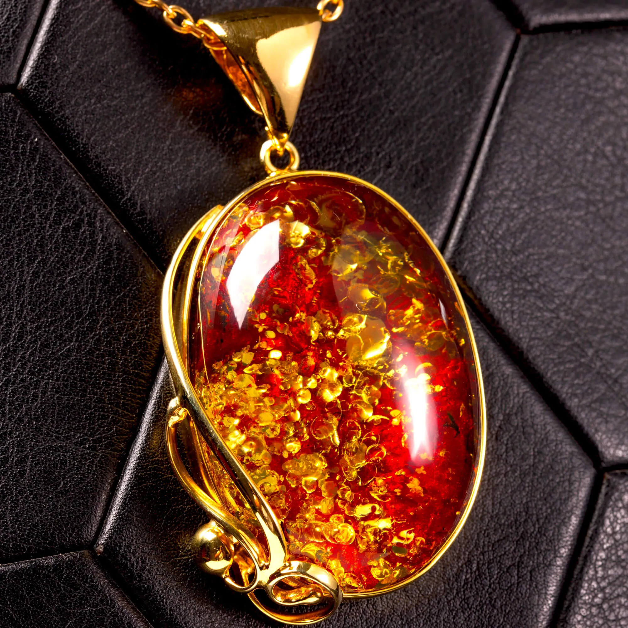 Ciondolo in ambra rosso cognac: gemma con inclusioni dorate, eleganza senza tempo.
