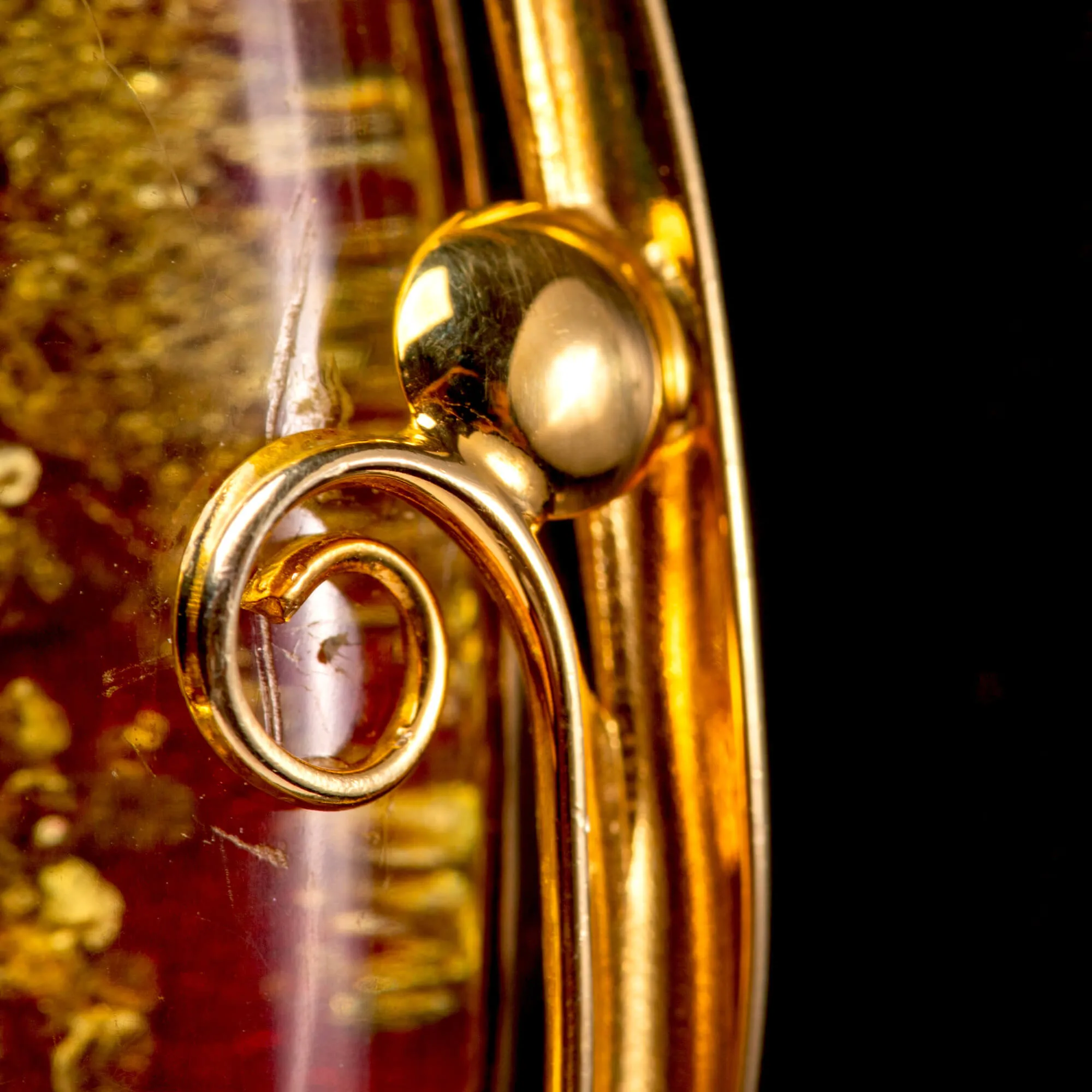 Ciondolo in ambra rossa: inclusioni dorate e raffinata eleganza.