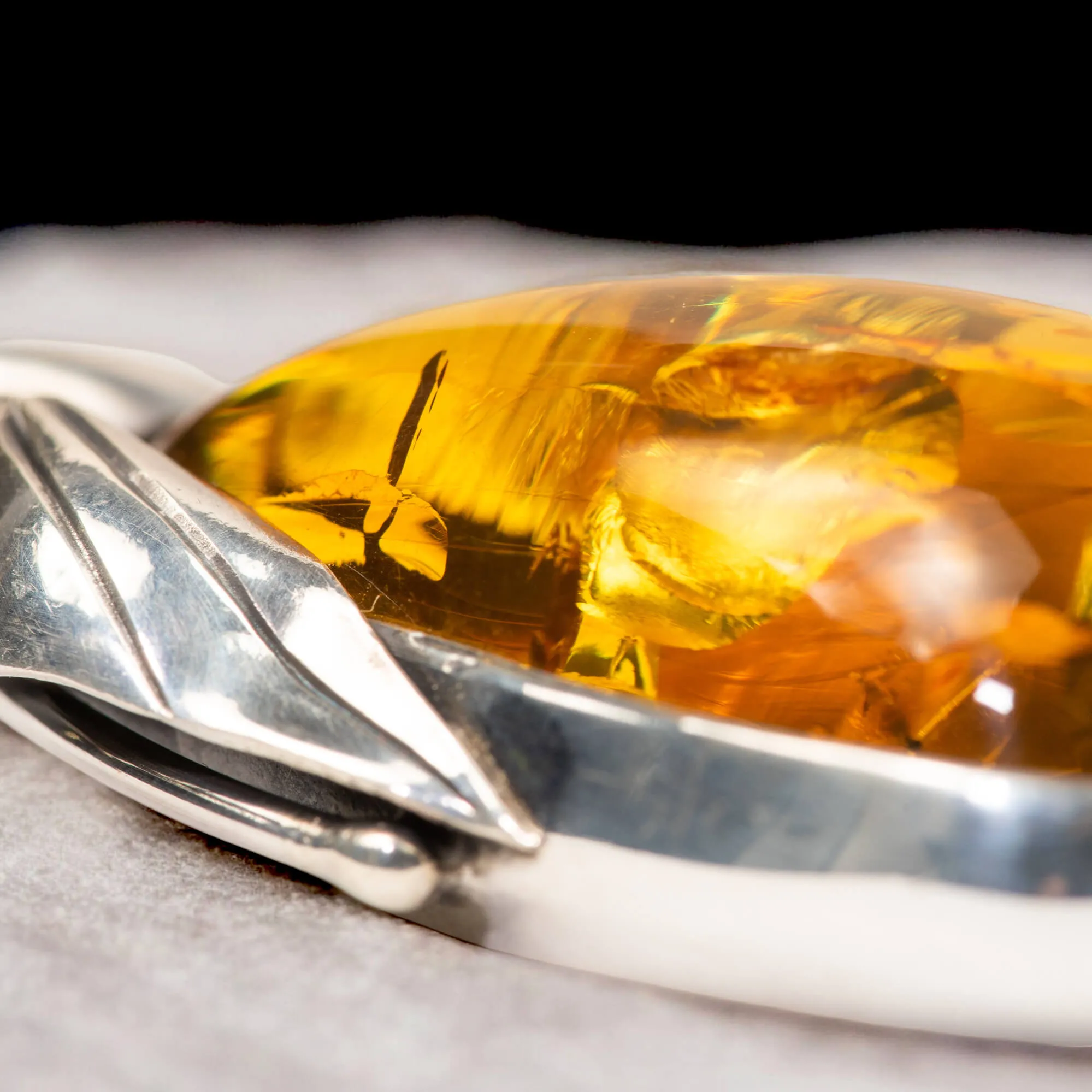 Ciondolo in argento con ambra color miele e inclusioni a forma di petali: eleganza naturale e armonia.