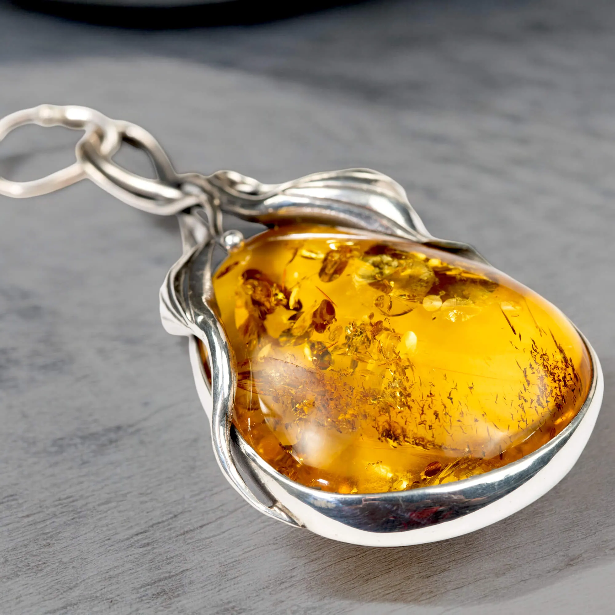 Ciondolo in argento con ambra color miele: fascino e protezione.