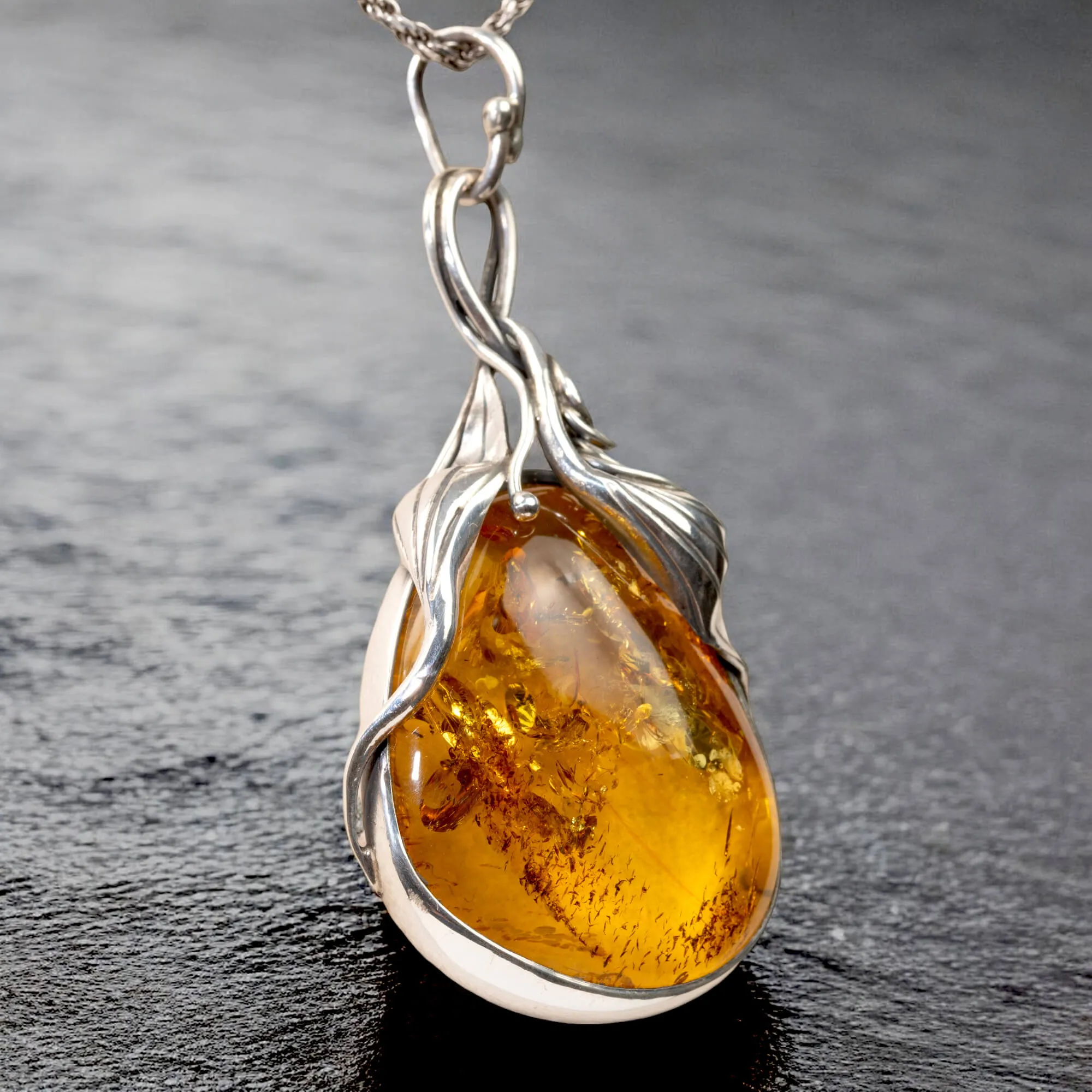 Ciondolo in argento con ambra color miele: fascino e protezione.
