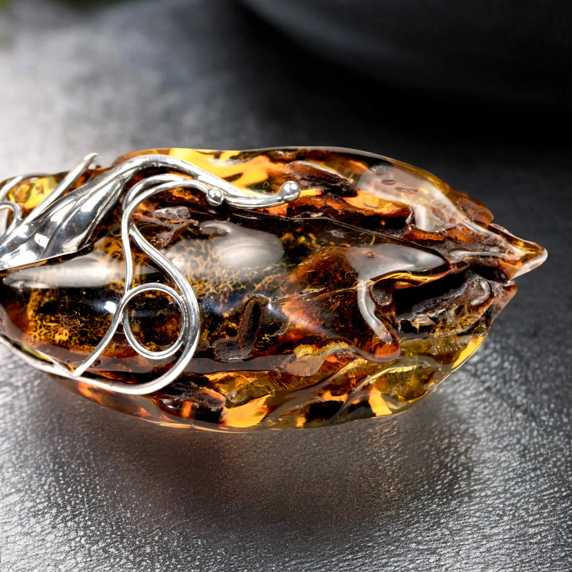 Ciondolo in argento con ambra grezza color cognac: connessione con la natura e protezione spirituale.