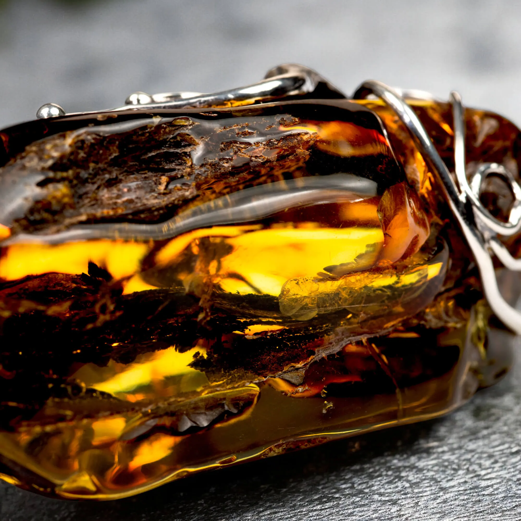 Ciondolo in argento con ambra grezza color cognac: connessione con la natura e protezione spirituale.