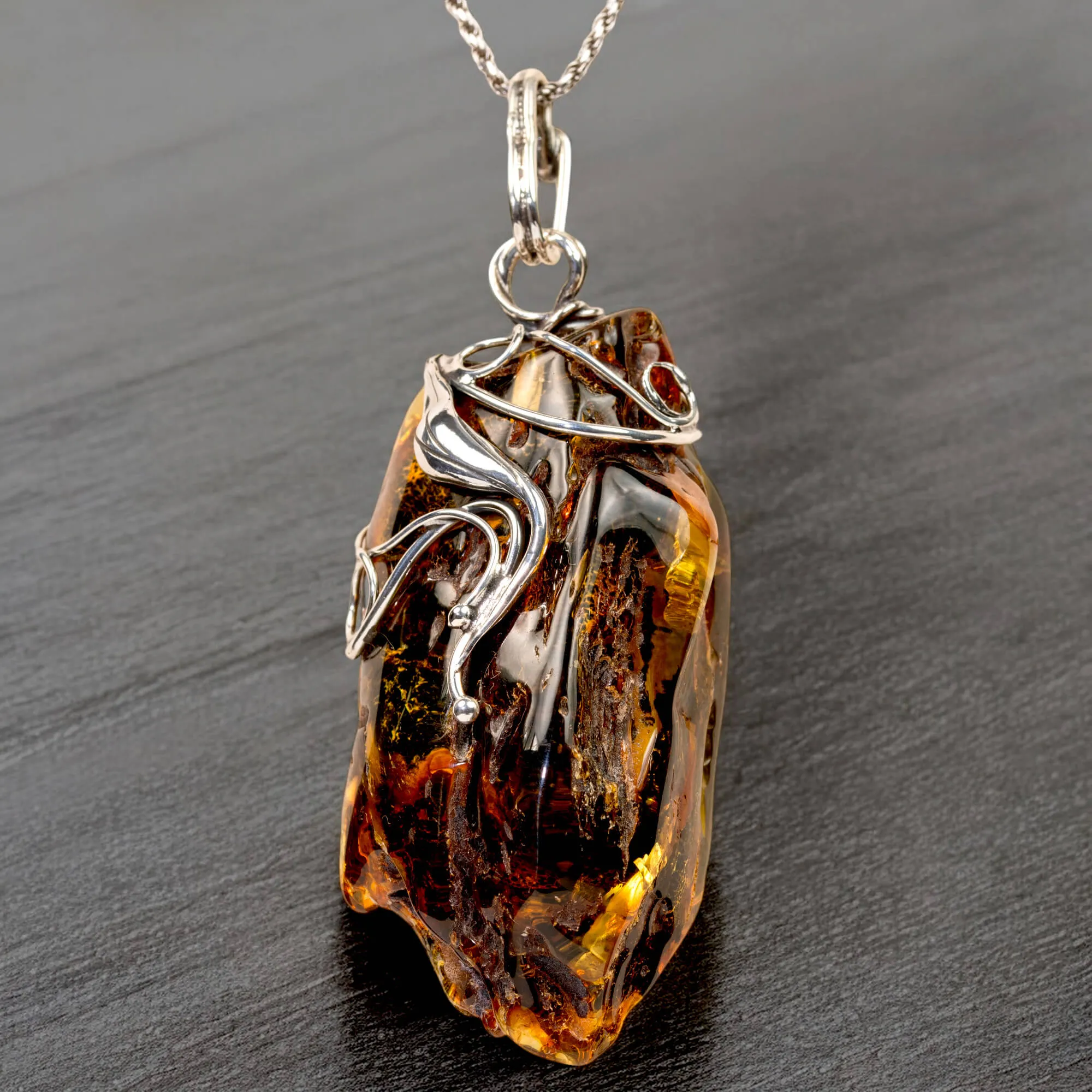 Ciondolo in argento con ambra grezza color cognac: connessione con la natura e protezione spirituale.