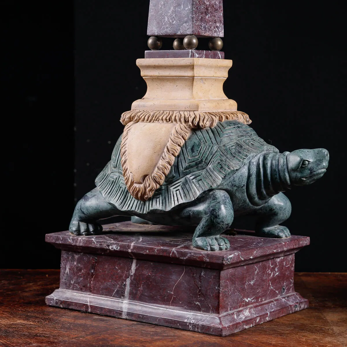 Coppia di obelischi in marmo con base scultorea a forma di tartaruga.